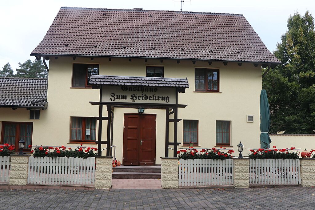 Ein helles Haus, mit dem Schriftzug "Zum Heidekrug" über dem Eingang